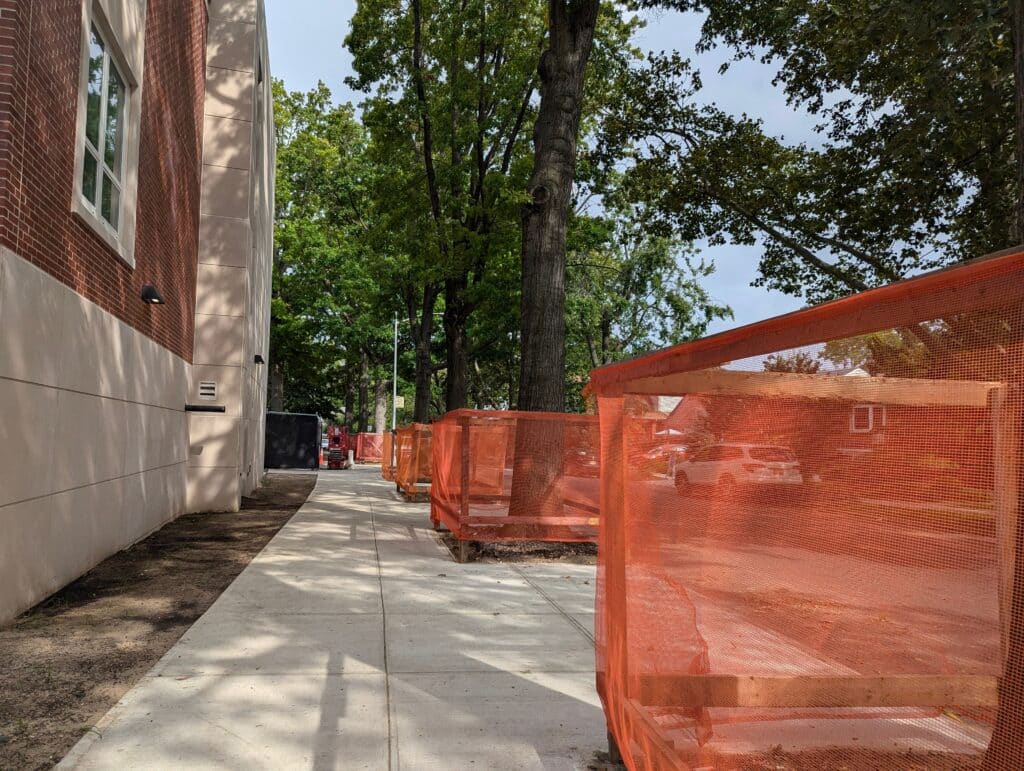 a row of orange mesh boxes on a sidewalk
